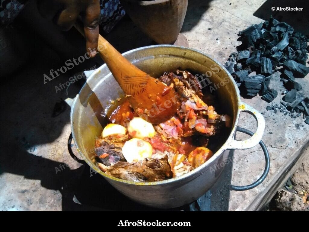 Woman Stirring Pots Over Fire, West Africa - AfroStocker