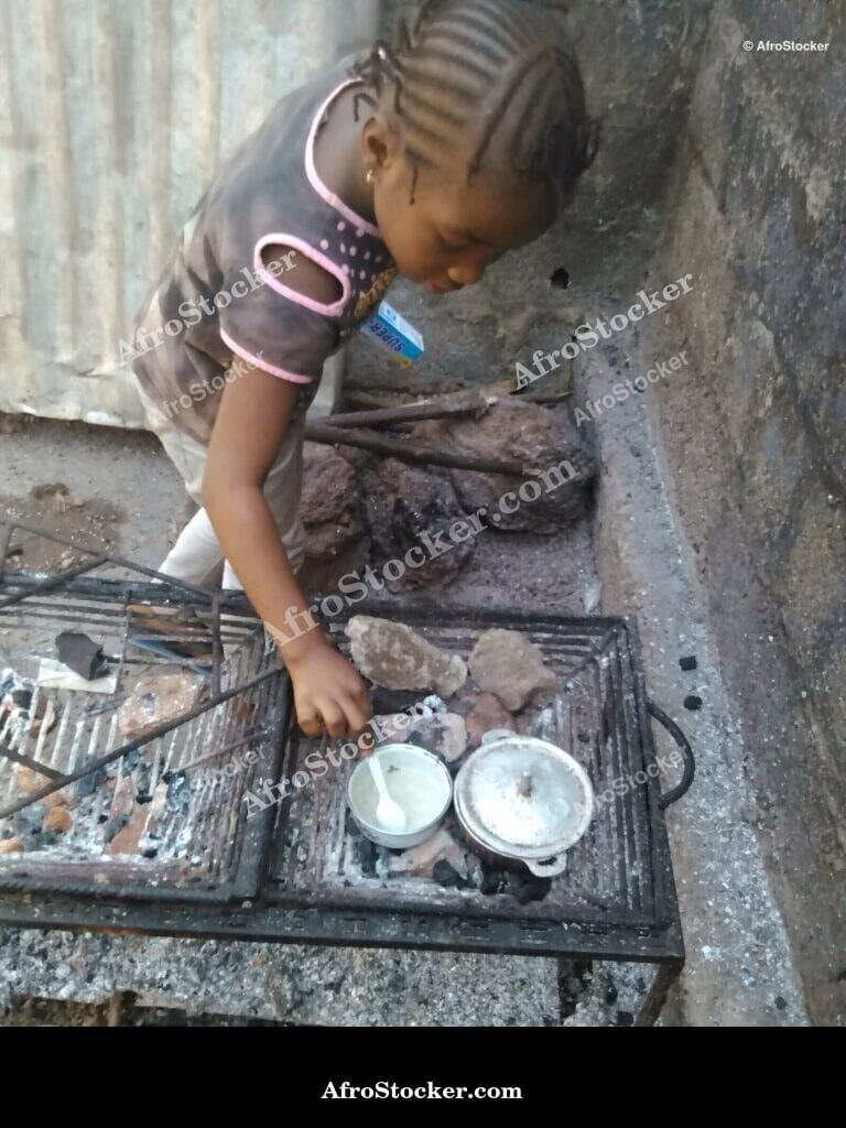 Young Girl Cooking Near Pots, Africa - AfroStocker
