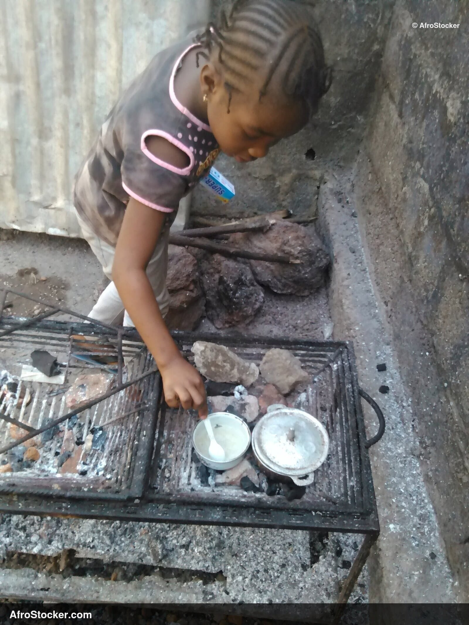 Young Girl Cooking Near Pots, Africa - AfroStocker