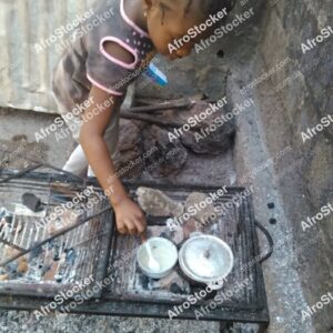 Young Girl Cooking Near Pots, Africa - AfroStocker